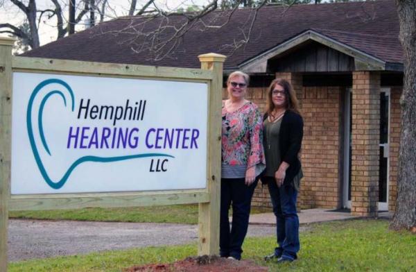 staff outside in front of sign