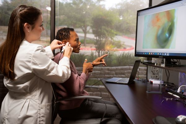 A woman receives a hearing exam.